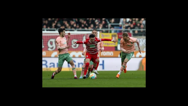 Cầu thủ Augsburg tiến vào vòng cấm Werder Bremen với bóng